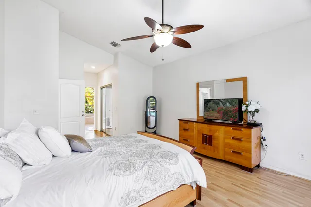 a bedroom with a bed and a flat tv screen on dresser