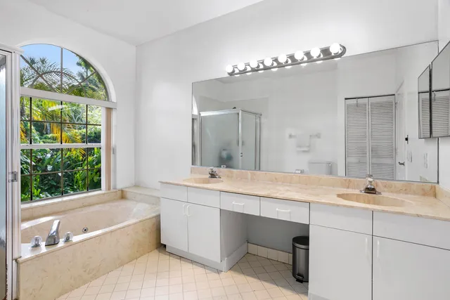 a bathroom with a tub a sink and a large mirror