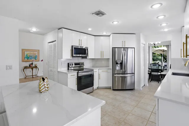 a kitchen with a refrigerator a stove top oven a sink a washer and a refrigerator