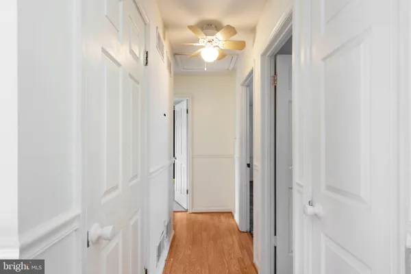 a view of a hallway with a chandelier fan