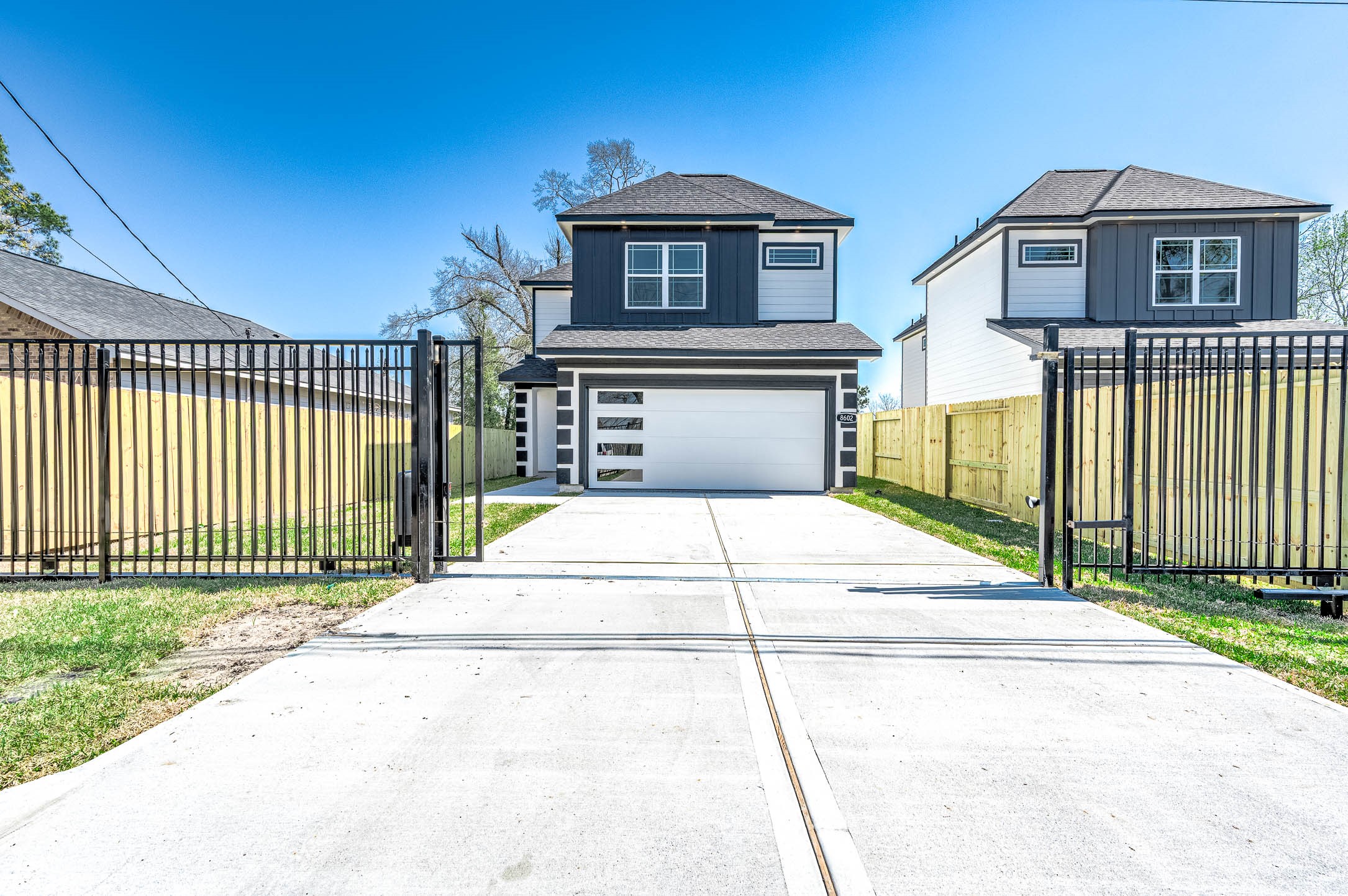8602 Hoffman Street Houston, TX 77016 - Photo 4 of 30 Modern two-story home with gated driveway entry and a spacious two-car garage.