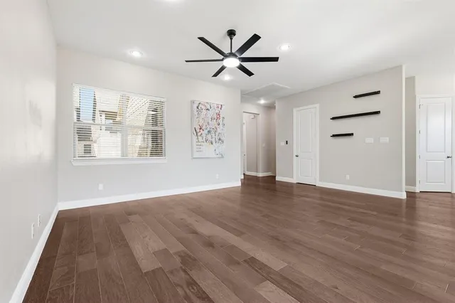a view of empty room with wooden floor and window