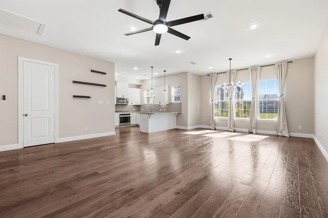a open kitchen with kitchen island a oven a counter space and wooden floor