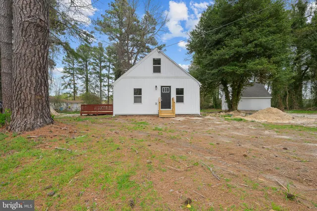 a front view of a house with a yard and trees