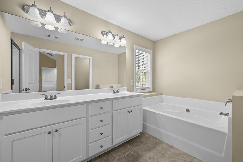 9 Bailee Circle Colbert, GA 30628 - Photo 18 of 30 a spacious bathroom with a double vanity sink large mirror and a bathtub