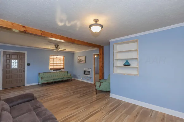 a view of a livingroom with wooden floor and a ceiling fan