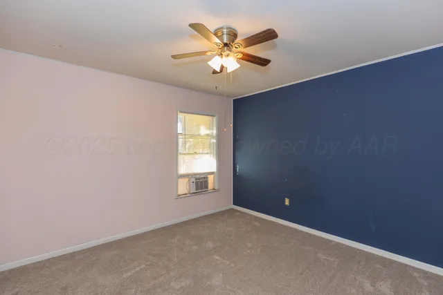 an empty room with a window and a ceiling fan