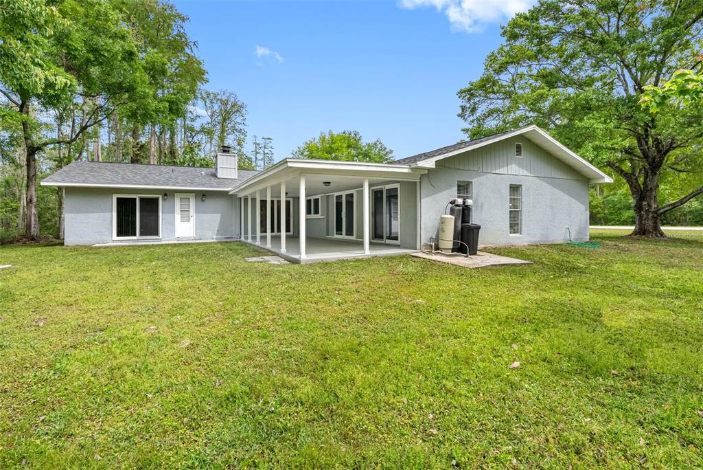 346 Ranch Road Tarpon Springs, FL 34688 - Photo 14 of 64 a front view of a house with a garden and trees