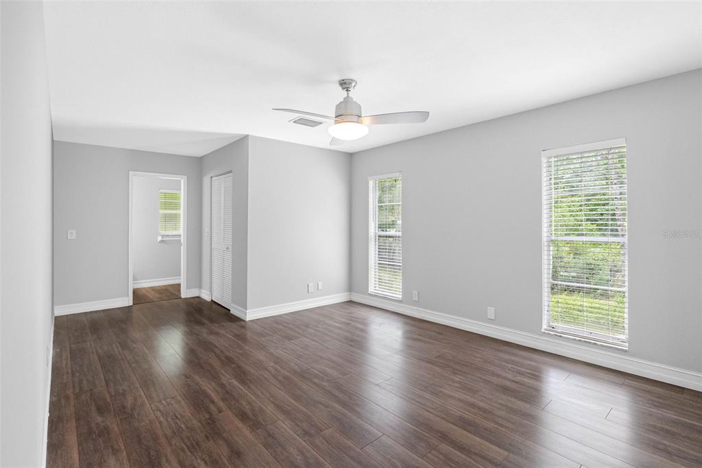 346 Ranch Road Tarpon Springs, FL 34688 - Photo 30 of 64 an empty room with wooden floor chandelier fan and windows
