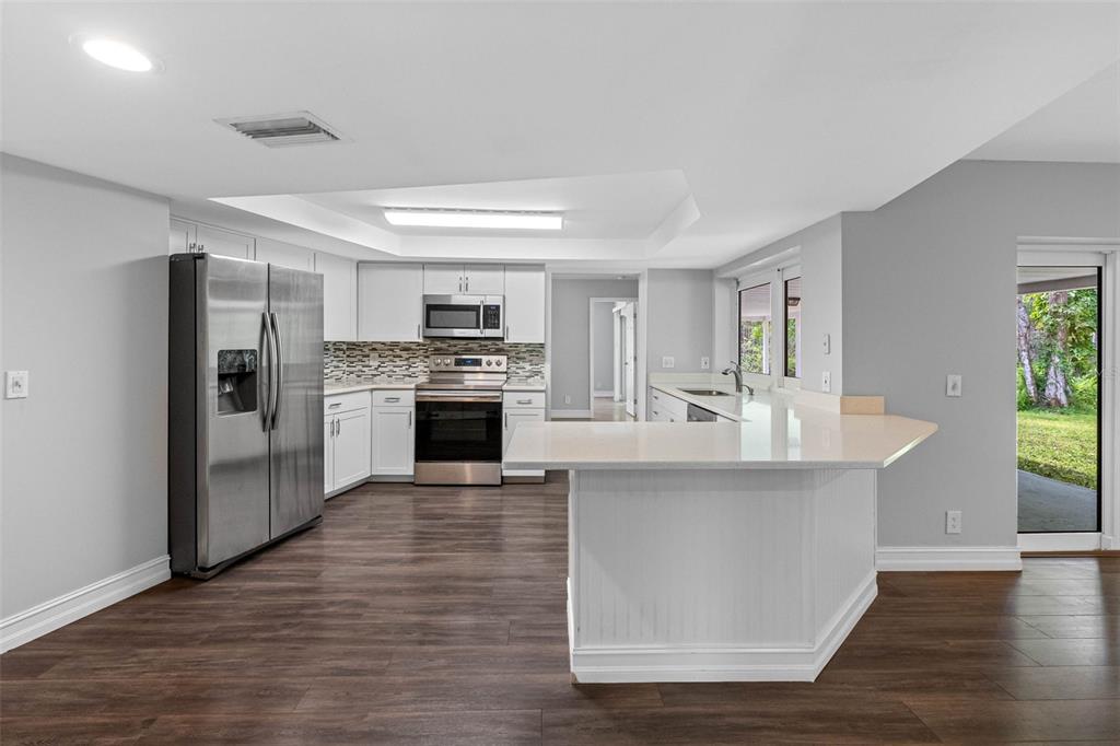 346 Ranch Road Tarpon Springs, FL 34688 - Photo 45 of 64 a large white kitchen with a stove a refrigerator and a fireplace