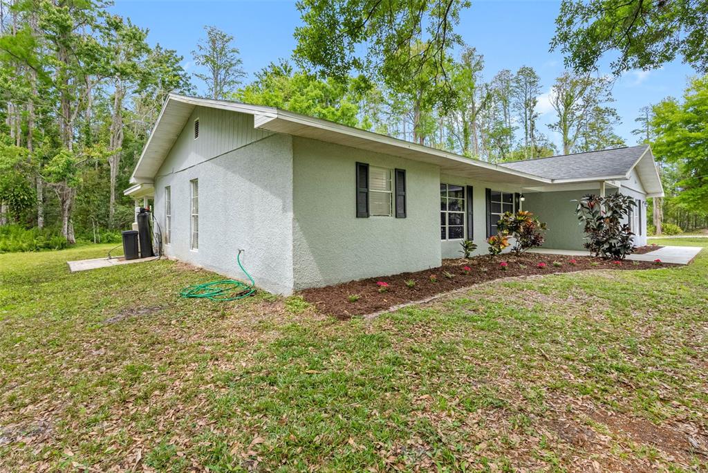 346 Ranch Road Tarpon Springs, FL 34688 - Photo 8 of 64 a backyard of a house with yard and outdoor seating
