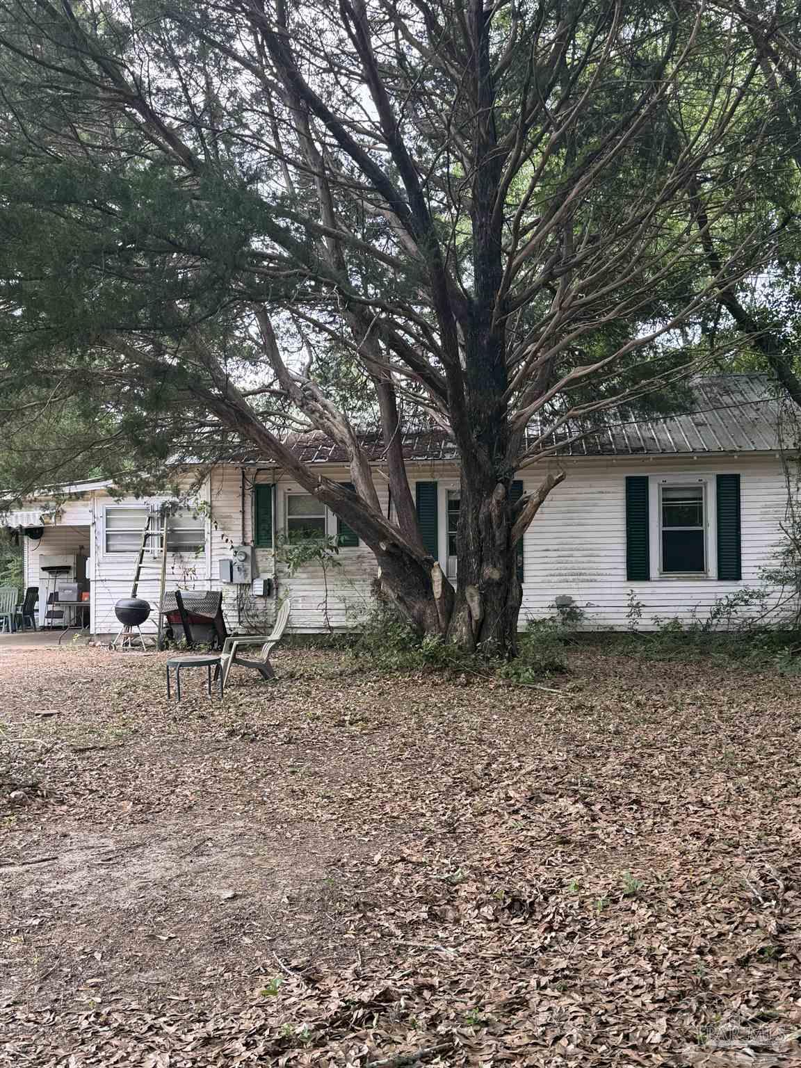 6042 Enfinger Road Pace, FL 32571 - Photo 2 of 10 a white house that has a tree in front of it