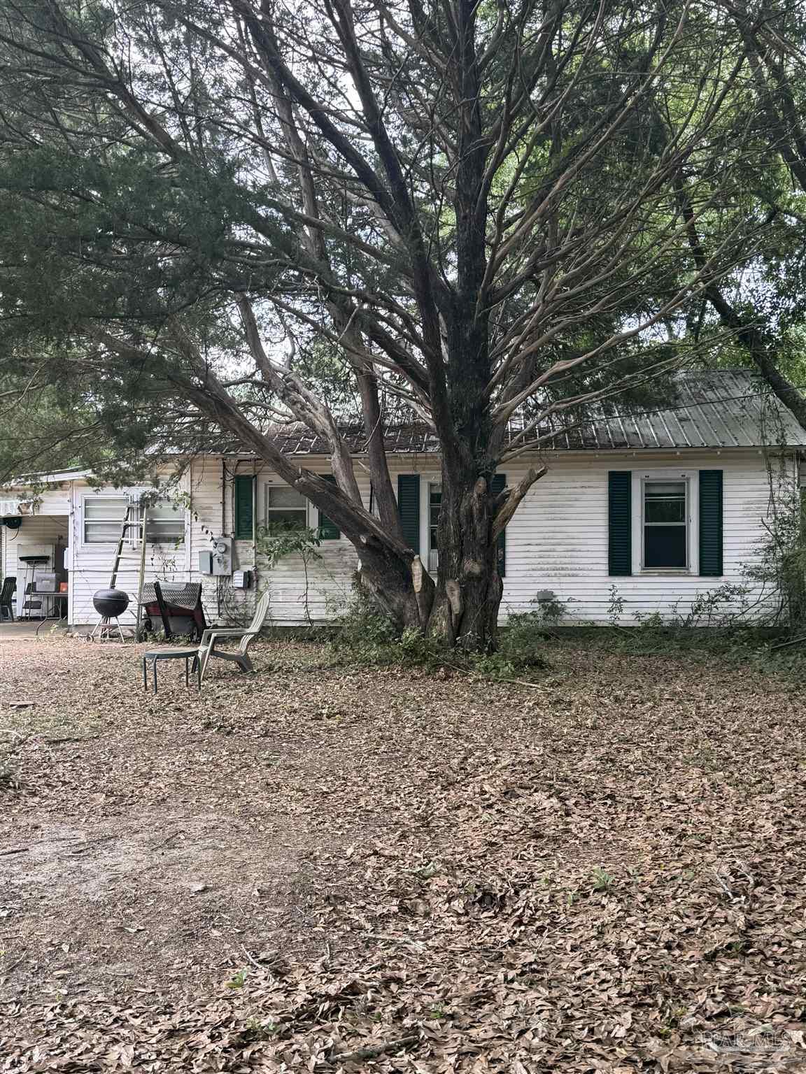 6042 Enfinger Road Pace, FL 32571 - Photo 4 of 10 a backyard of a house with barbeque oven table and chairs