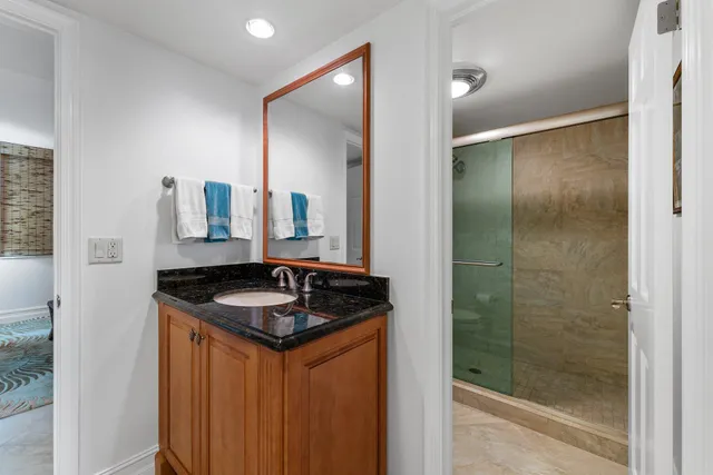 a bathroom with a granite countertop sink and a mirror