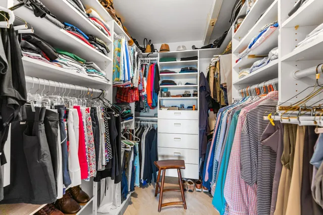a view of walk in closet with clothes and shoes