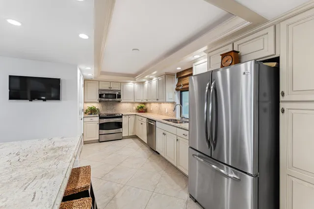 a kitchen with stainless steel appliances a refrigerator and a stove top oven