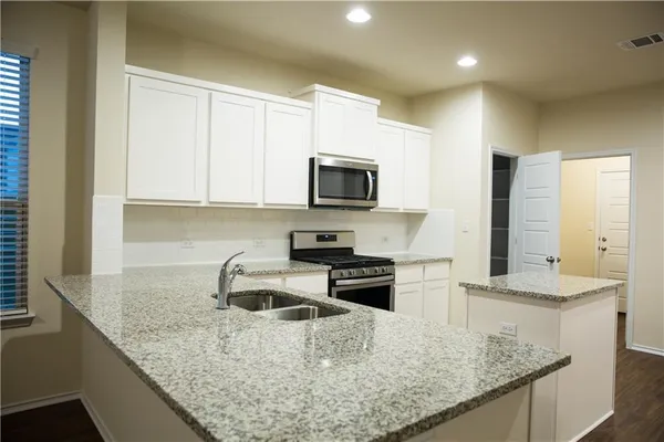 a kitchen with sink a microwave and stove