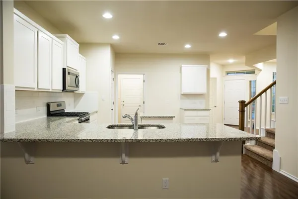 a view of a kitchen with wooden floor and a window