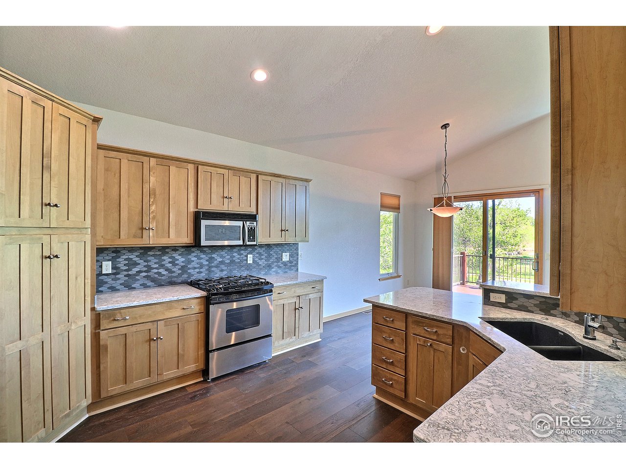 7205 Poudre River Road, Unit 3 Greeley, CO 80634 - Photo 6 of 27 Gas range and microwave flanked by stone backsplash