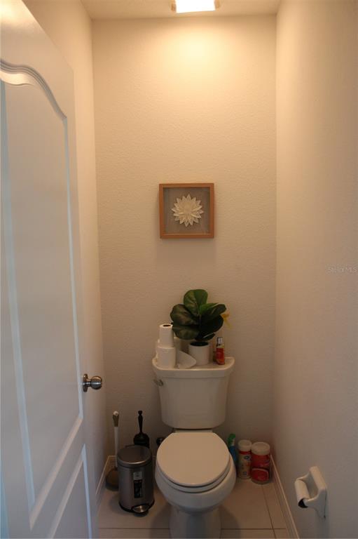 2591 Wadeview Loop St. Cloud, FL 34769 - Photo 12 of 18 a white toilet sitting next to a white sink and vanity