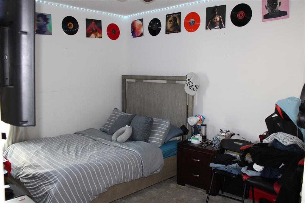 2591 Wadeview Loop St. Cloud, FL 34769 - Photo 13 of 18 a bedroom with a bed and a white cabinet