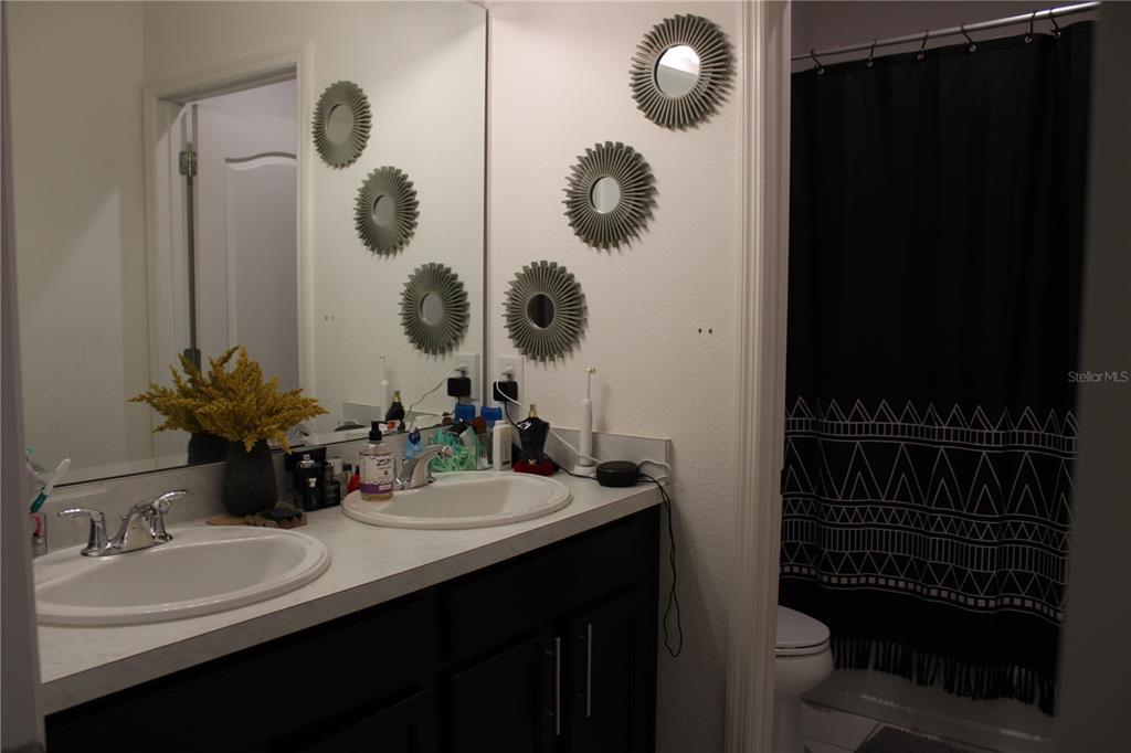 2591 Wadeview Loop St. Cloud, FL 34769 - Photo 14 of 18 a bathroom with a sink and mirror