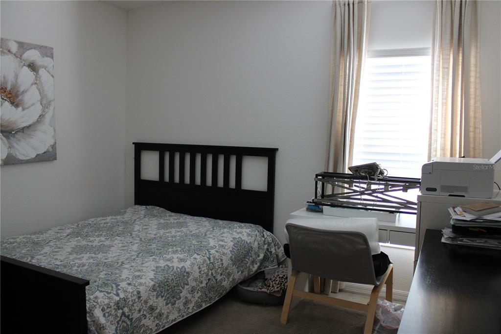 2591 Wadeview Loop St. Cloud, FL 34769 - Photo 15 of 18 a bedroom with a bed and chair