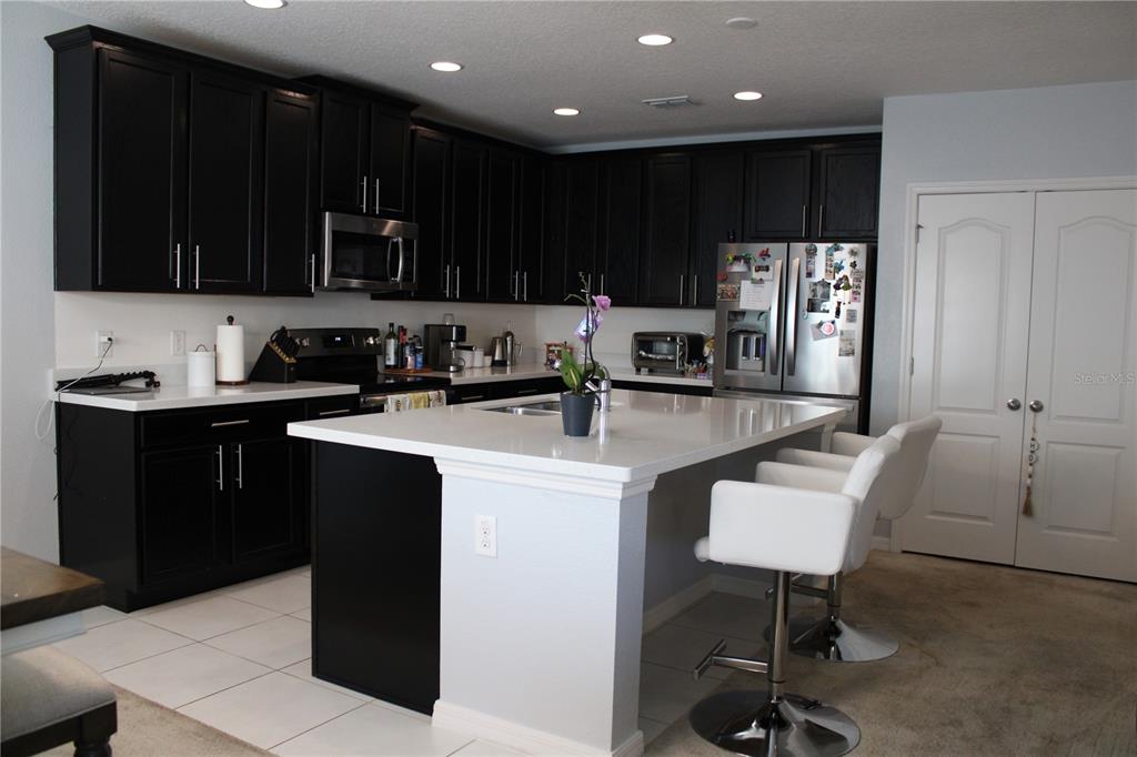 2591 Wadeview Loop St. Cloud, FL 34769 - Photo 4 of 18 a kitchen with stainless steel appliances a sink a stove a refrigerator and cabinets