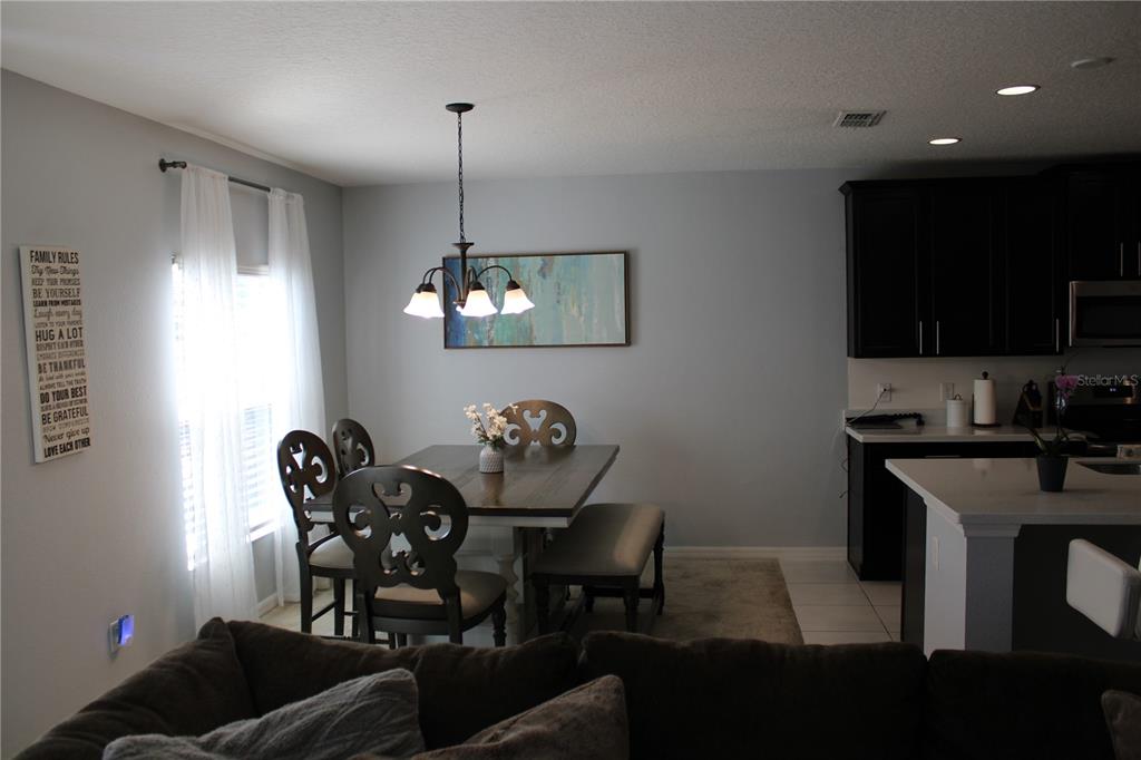 2591 Wadeview Loop St. Cloud, FL 34769 - Photo 7 of 18 a view of a dining room with furniture and wooden floor