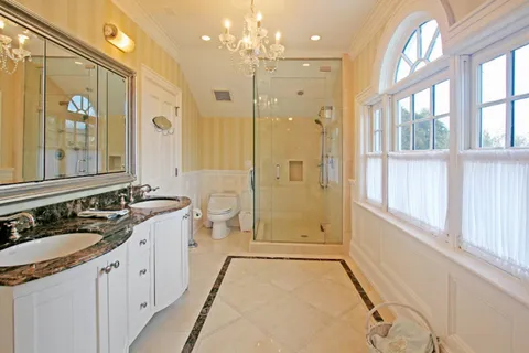 a spacious bathroom with a double vanity sink a large mirror a shower and a bathtub