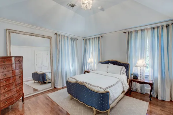 a bedroom with a bed lamp and a large window