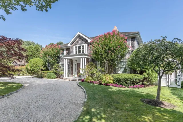 a front view of a house with a yard and potted plants