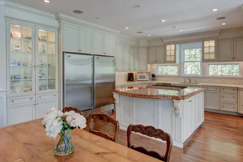 a kitchen with stainless steel appliances granite countertop a sink a stove and refrigerator