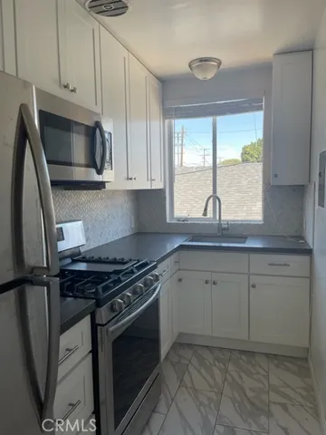 a kitchen with granite countertop a sink stove and cabinets