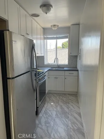 a kitchen with stainless steel appliances granite countertop a refrigerator sink and cabinets