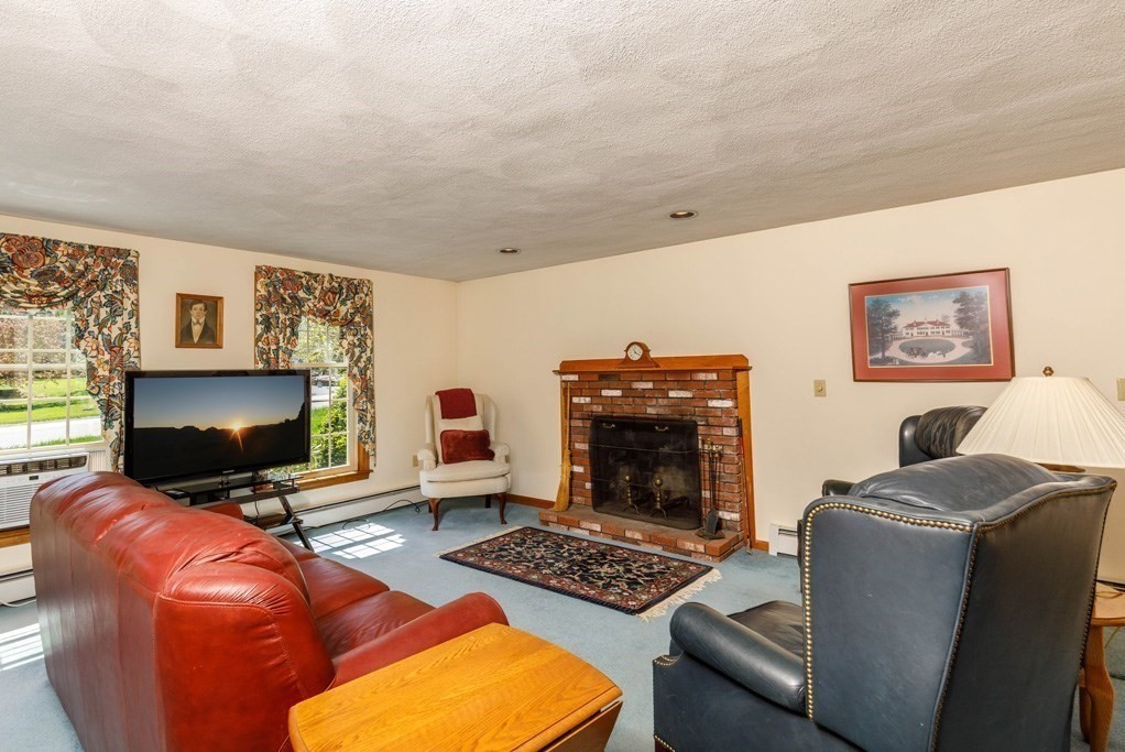 202 Leo Drive Gardner, MA 01440 - Photo 9 of 26 a living room with furniture a flat screen tv and a fireplace