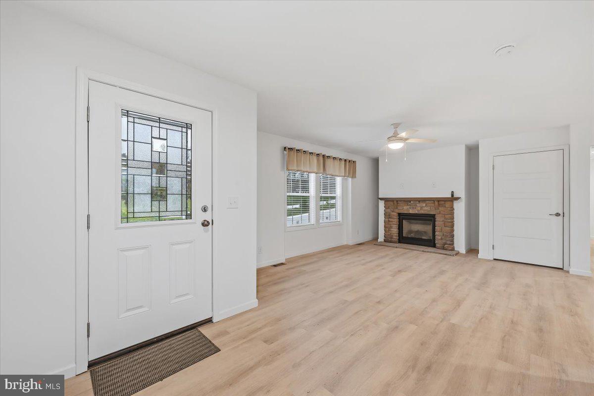 3987 Hastings Road Walnutport, PA 18088 - Photo 4 of 40 an empty room with wooden floor fireplace and windows