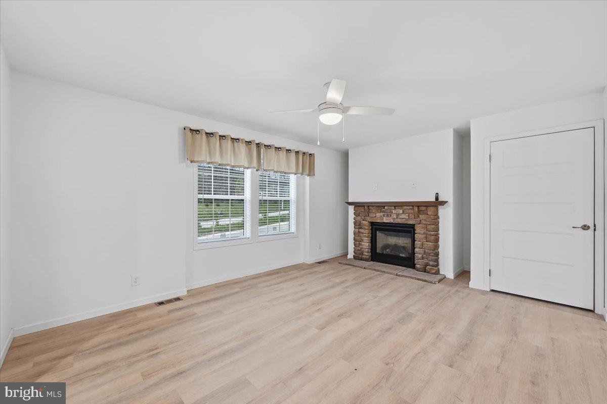 3987 Hastings Road Walnutport, PA 18088 - Photo 5 of 40 an empty room with windows fireplace and fans
