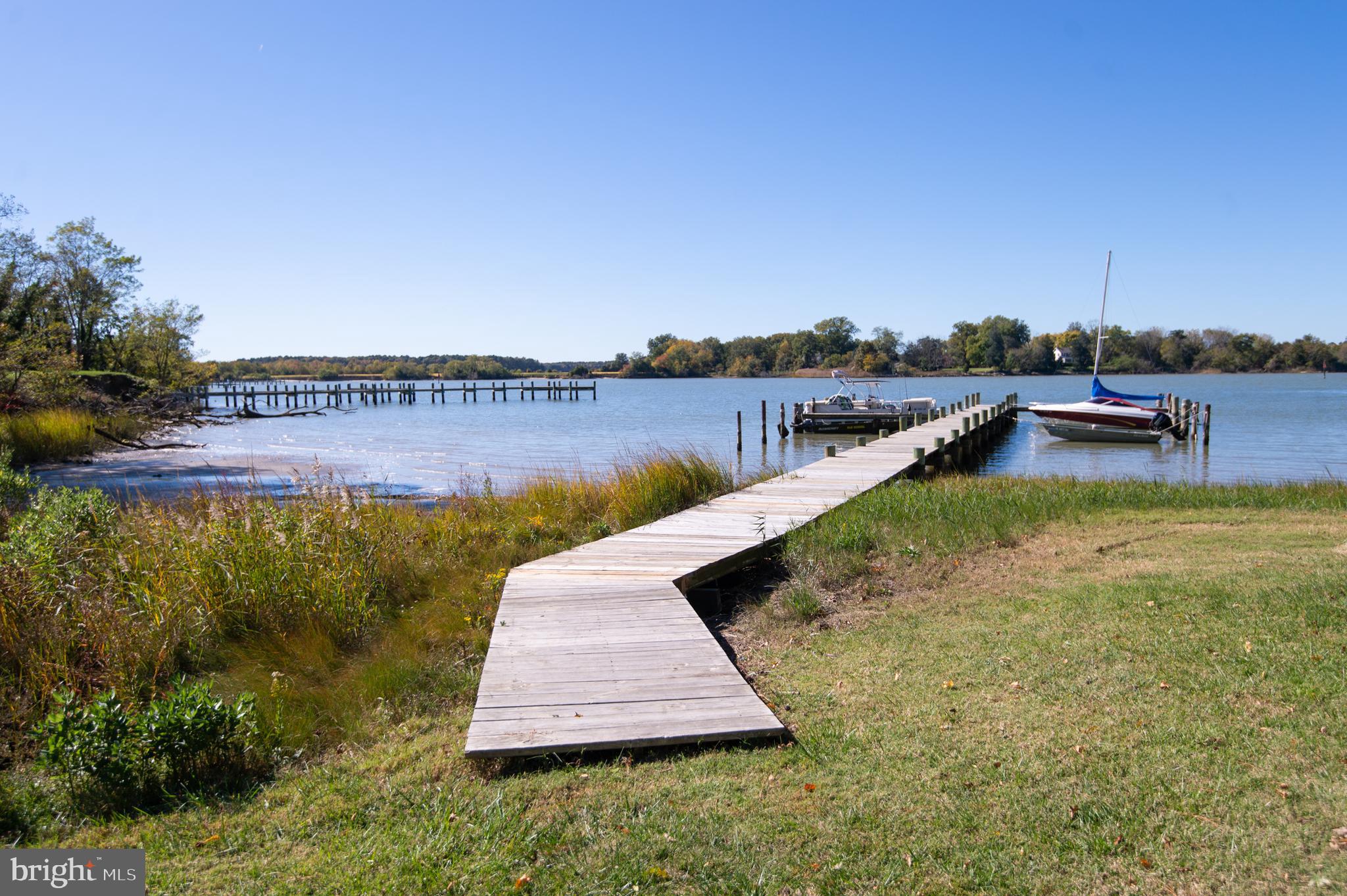 a view of a lake with a yard and potted plants