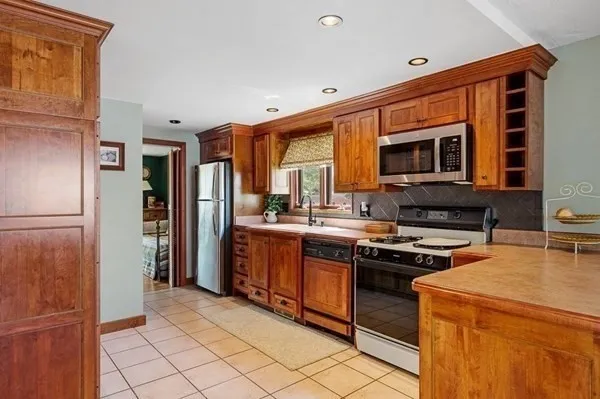a kitchen with stainless steel appliances granite countertop a refrigerator stove and sink