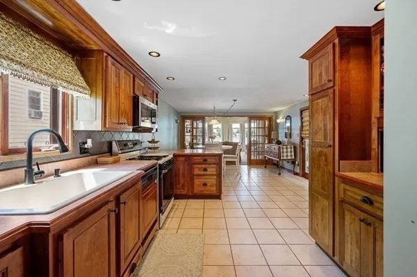 a large kitchen with stainless steel appliances granite countertop a sink and cabinets
