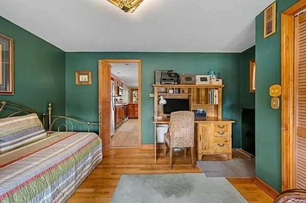 a bedroom with a bed and wooden floor