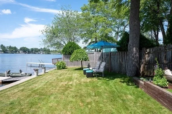 a view of a backyard with a table and chairs under an umbrella