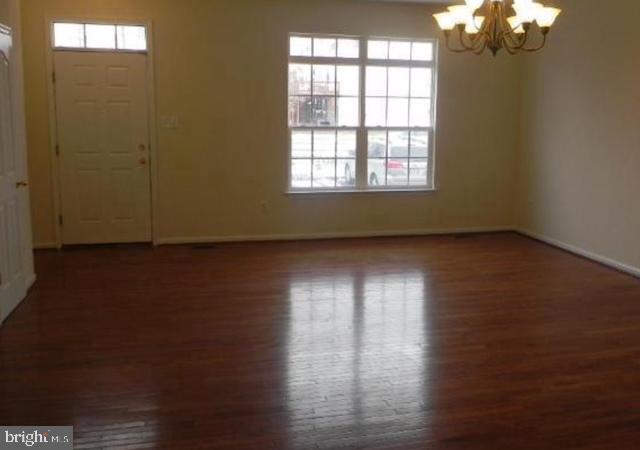 20118 Gunners Terrace Germantown, MD 20876 - Photo 5 of 12 an empty room with wooden floor and windows in it