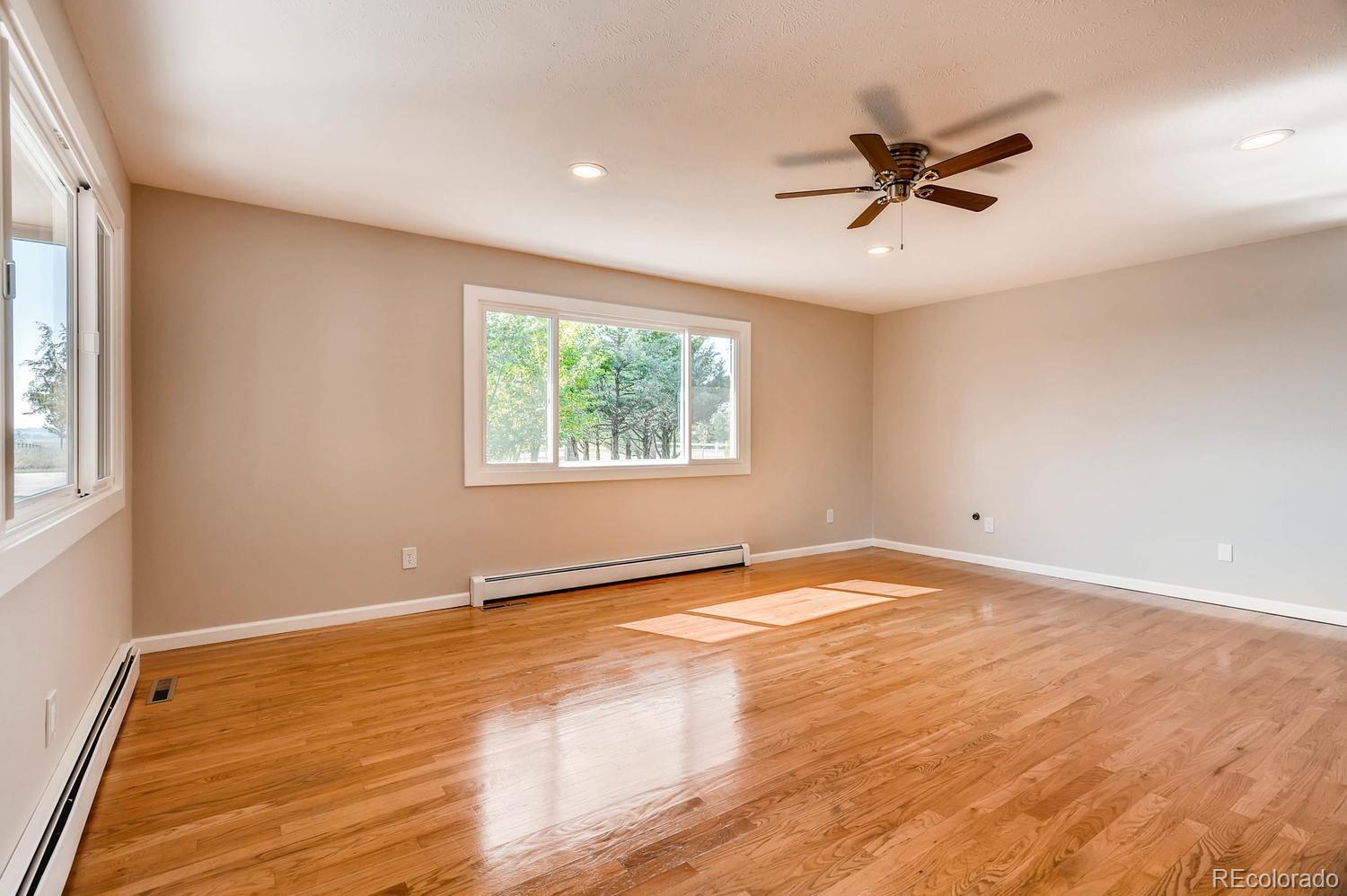 9907 Phillips Road Lafayette, CO 80026 - Photo 20 of 31 a view of an empty room with window and wooden floor