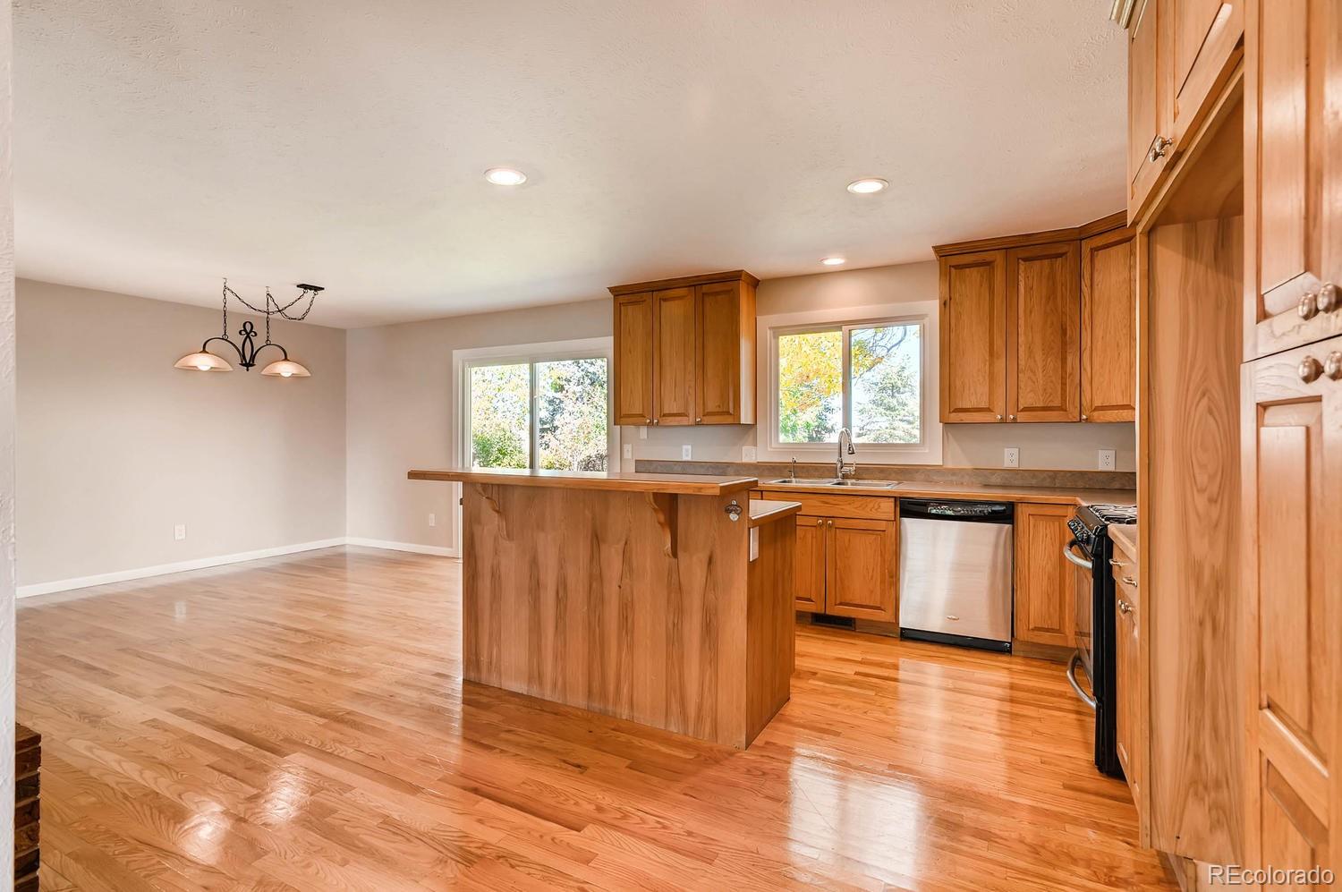 9907 Phillips Road Lafayette, CO 80026 - Photo 23 of 31 a kitchen with granite countertop wooden floors and wide window