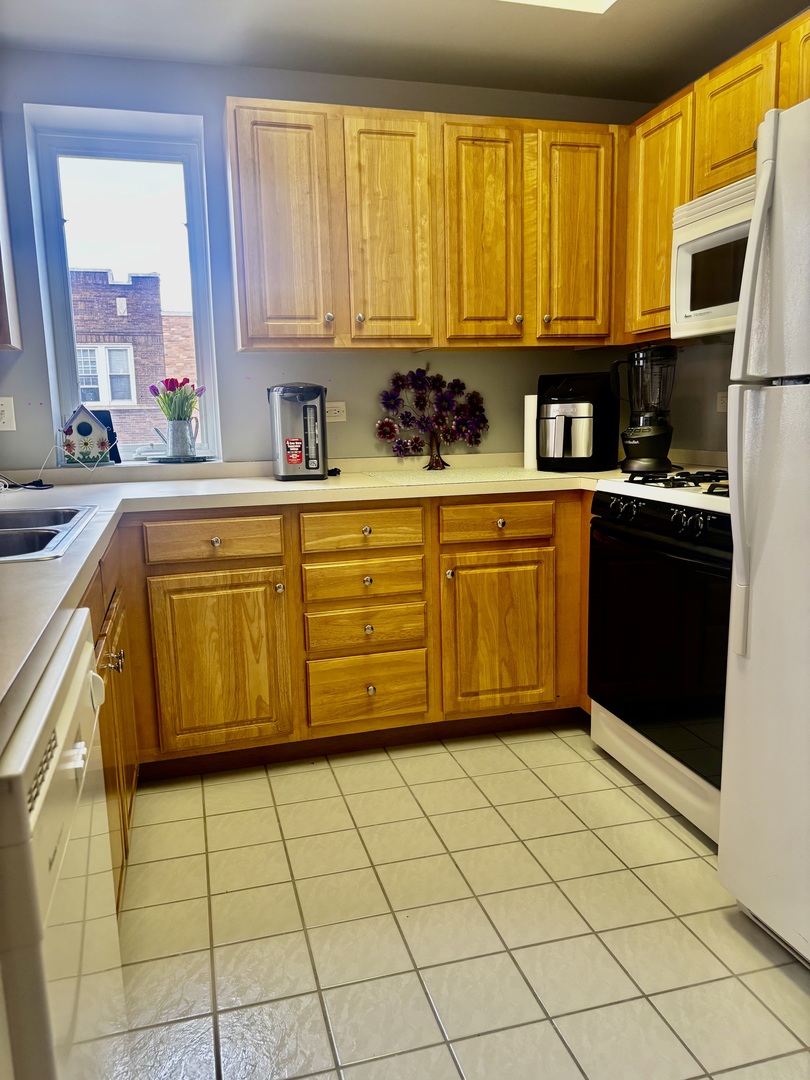 6238 West 26th Street, Unit 201 Berwyn, IL 60402 - Photo 11 of 30 a kitchen with stainless steel appliances granite countertop a stove a sink and a microwave