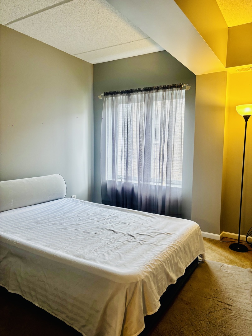 6238 West 26th Street, Unit 201 Berwyn, IL 60402 - Photo 16 of 30 a bedroom with a bed and wooden floor