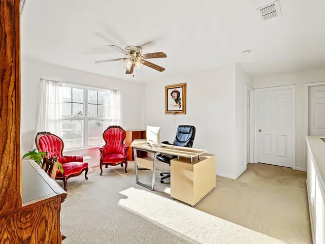a view of a workspace with furniture and a window