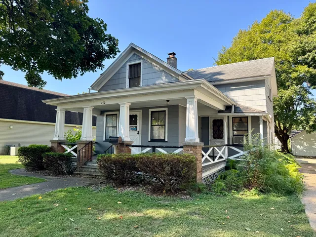 a front view of a house with a garden and porch